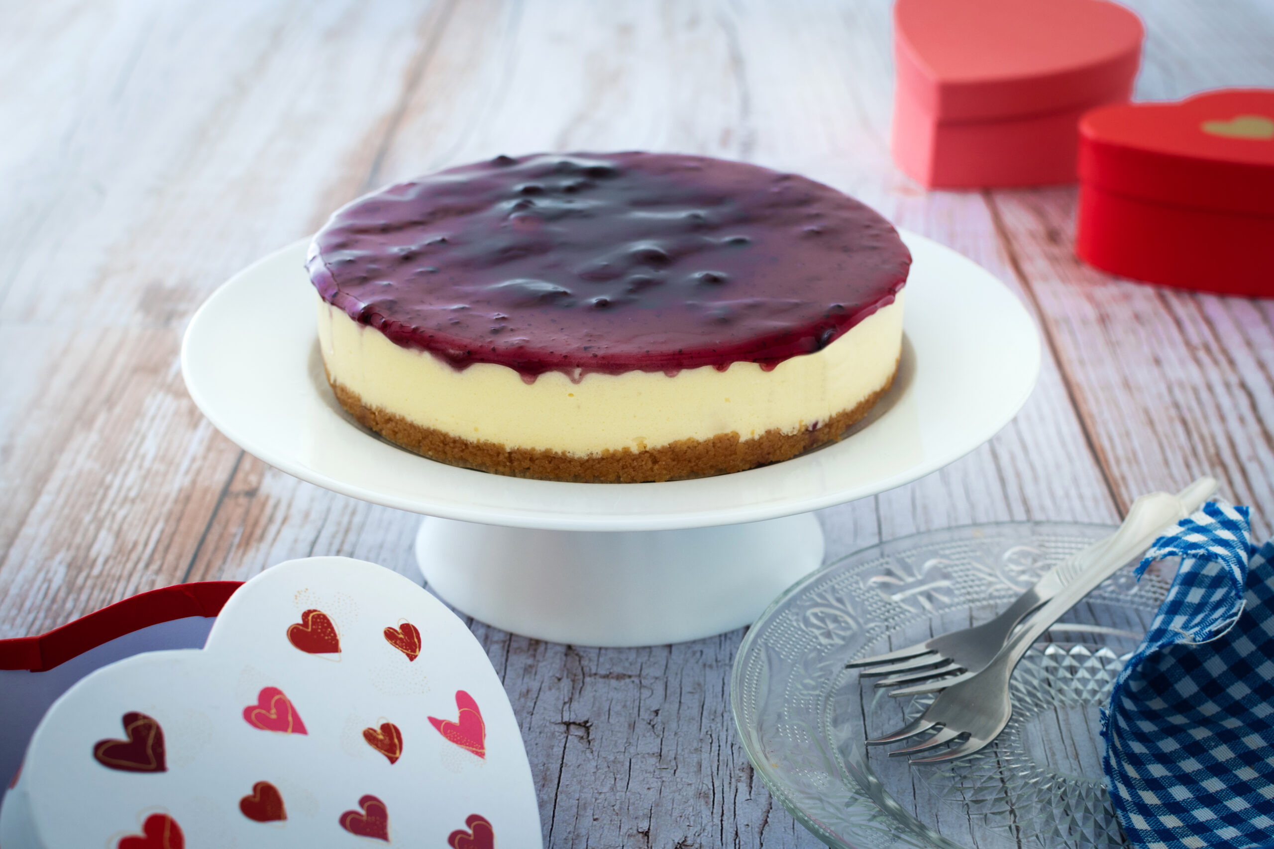 Blueberry cheesecake decorated with sweet hearts on wooden table